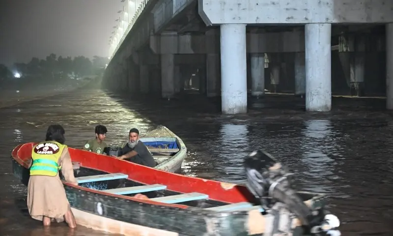 Members of Civil Defence prepare their boats along the bank of the Ravi River after the rising floodwaters affected the Shahdara area in Lahore, on August 27. — AFP
