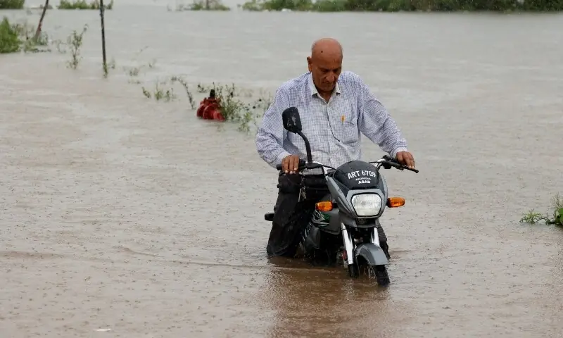  A man rides a motorbike on a flooded street following monsoon rains and rising water levels in Sialkot in on August 27. &mdash; Reuters 