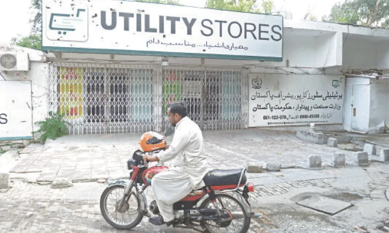 A motorcyclist rides past a closed outlet of Utility Stores Corporation in G-6 area of Islamabad on July 31, 2025. &mdash; Photo by Mohammad Asim