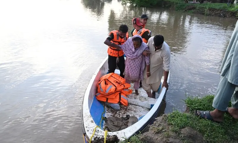 Rescuers in a small boat evacuate residents from the flooded area of Narowal on August 27. &mdash; AFP