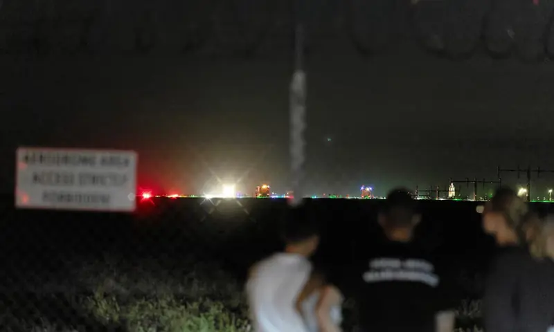 People stand near the scene where a Polish Air Force F-16 fighter jet crashed during a rehearsal for an airshow, in Radom, Poland on August 28, 2025. &mdash; Agencja Wyborcza.pl/Marcin Kucewicz via Reuters