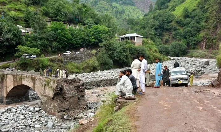 Onlookers gather near a destroyed bridge after flash floods on the outskirts of Muzaffarabad, the capital of Azad Kashmir, on Aug 15, 2025. &mdash; AFP