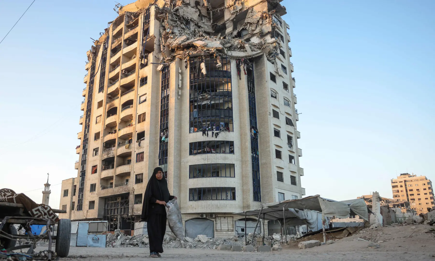  A Palestinian woman walks past a heavily damaged building in Gaza City on August 29, 2025. &mdash; AFP 