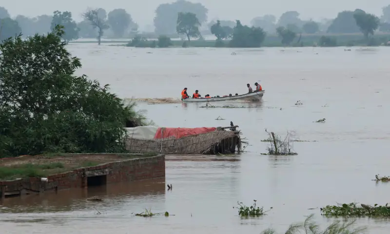 A Rescue 1122 boat evacuates people from the flooded area past partially submerged houses, following the monsoon rains and rising water level of the Sutlej River, in Chanda Singh Wala village near the Pakistan-India border in Punjab’s Kasur district, on August 29. — Reuters