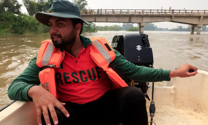 Muhammad Arslan, 27, an operator at Rescue 1122, drives a boat heading to evacuate residents, following the monsoon rains and rising water level of the Sutlej River, in Talwar Check Post near the Pakistan-India border in Punjab’s Kasur district, on August 29. — Reuters