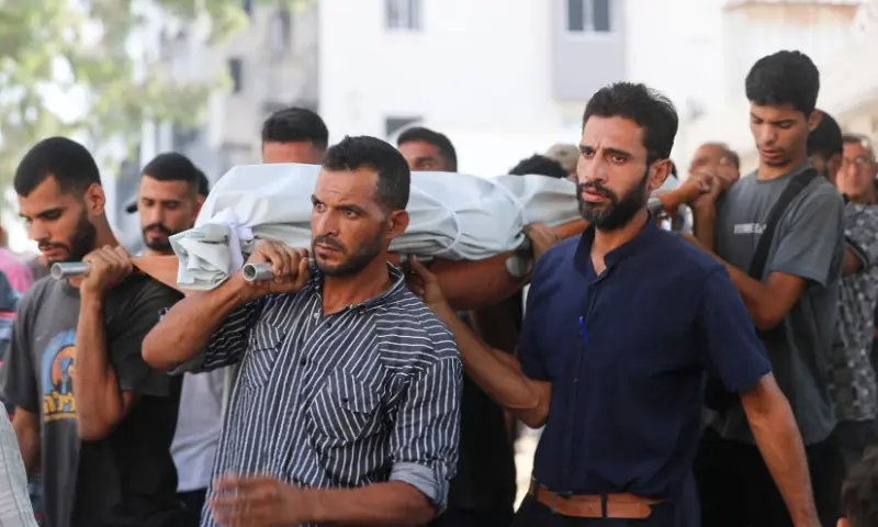 Mourners carry a body during the funeral of Palestinians who were killed by Israeli fire while trying to receive aid and another killed in a strike on Friday, according to medics, at Al-Shifa Hospital in Gaza City, on August 30. &mdash; Reuters