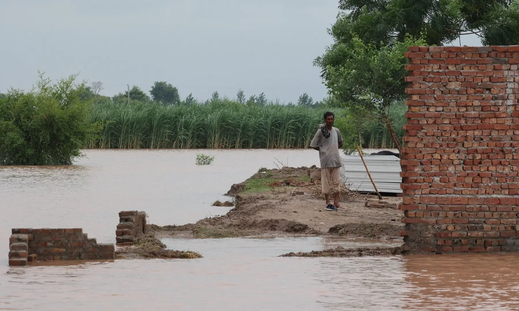 A man stands near the remains of his damaged house following monsoon rains and rising water levels of the Chenab River, in Harsa Bhula village, Chiniot district, Punjab on August 30, 2025. &mdash; Reuters/Akhtar Soomro