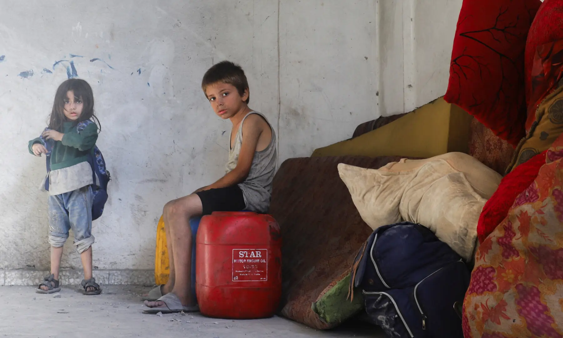 Children look on as Palestinians remove their belongings from a house damaged by an Israeli strike on a nearby home, in Gaza City on August 26, 2025. — Reuters/Ebrahim Hajjaj