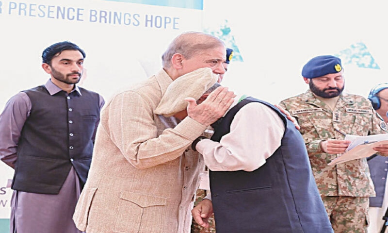 GILGIT: Prime Minister Shehbaz Sharif consoles an elderly man as he distributes compensation and relief cheques amongst those affected by recent floods in Gilgit-Baltistan.&mdash;APP
