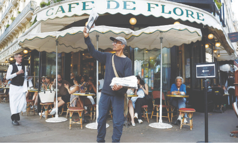 ALI Akbar sells a copy of Le Monde in Paris’s Latin quarter.—Reuters ALI Akbar sells a copy of Le Monde in Paris’s Latin quarter.—Reuters