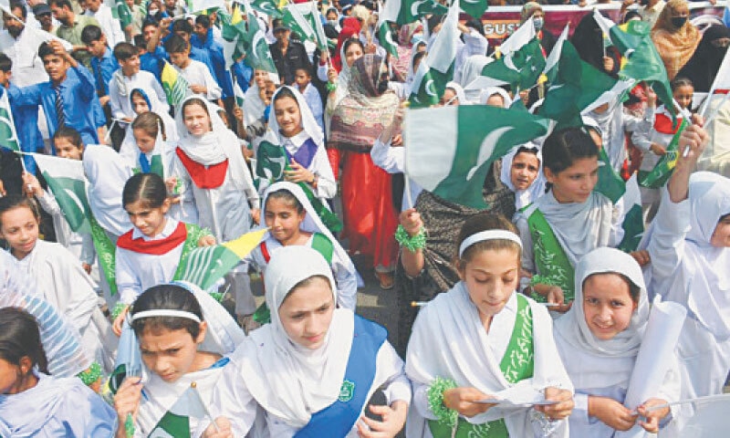 Schoolchildren wave Pakistani and AJK flags during a walk held in Peshawar on Tuesday to mark Youm-i-Istehsal. &mdash; White Star