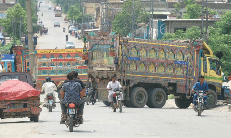 The Rawalpindi district administration has parked trucks to block road leading to Adiala Jail on Tuesday. — Photo by Mohammad Asim The Rawalpindi district administration has parked trucks to block road leading to Adiala Jail on Tuesday. — Photo by Mohammad Asim