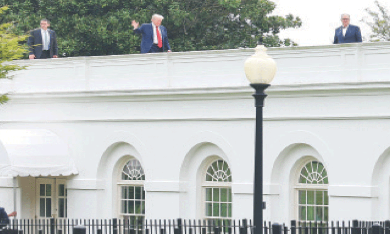 President Donald Trump waves from the roof as he gets a different view of the site of the proposed ballroom at the White House.&mdash;Reuters