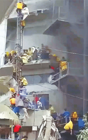 FACTORY workers trapped inside the burning building descend from an upper storey using a nearby power pylon.—PPI