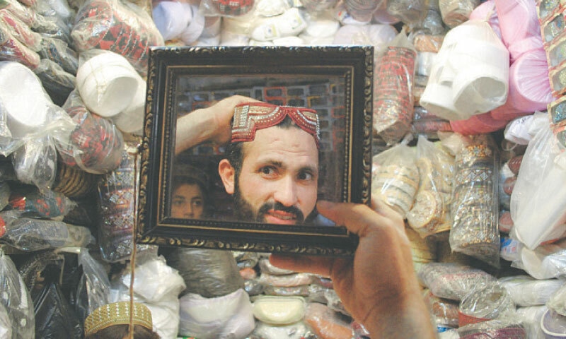  A man tries on a cap at a shop in Peshawar | Shahbaz Butt/White Star 