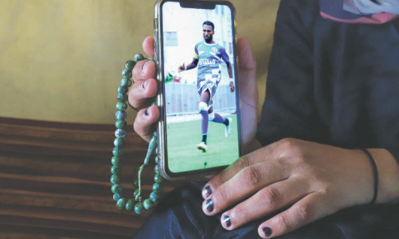  Doaa, the widow of late soccer player Suleiman Al-Obeid, known as the  ‘Palestinian Pele’, shows his picture on a mobile phone inside their tent in Gaza City. He was killed by an Israeli strike targeting people waiting for humanitarian aid, according to the Palestine Football Association.—Reuters 