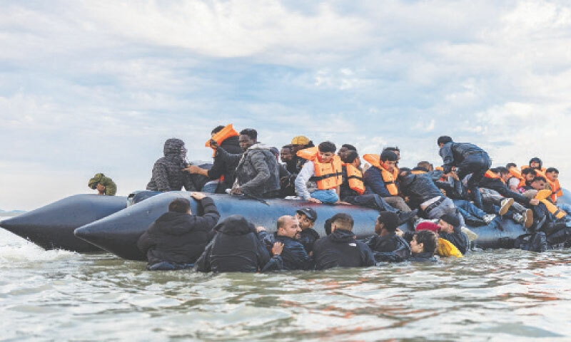 Gravelines: Migrants try to board a smuggler&rsquo;s boat in an attempt to cross the English Channel off northern France, on Tuesday. The perilous Channel crossing on small, overloaded boats often results in tragedies. Just last year, 52 migrants died while attempting to cross the Channel.&mdash;AFP