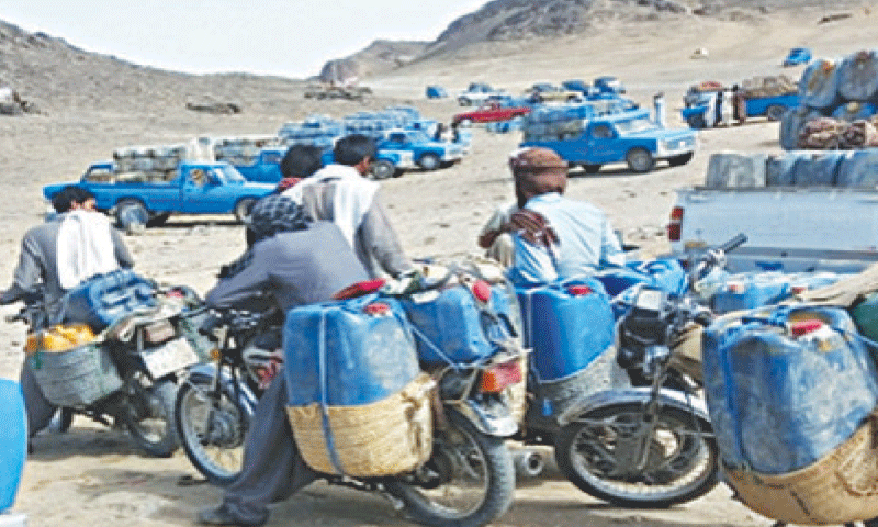 Smugglers on motorcycles prepare to transport Iranian petrol and diesel across the border into Pakistan. Captured in 2019, the image reflects the scale of illegal fuel transport that continues to cost the national exchequer hundreds of billions of rupees annually.&mdash;Dawn/file