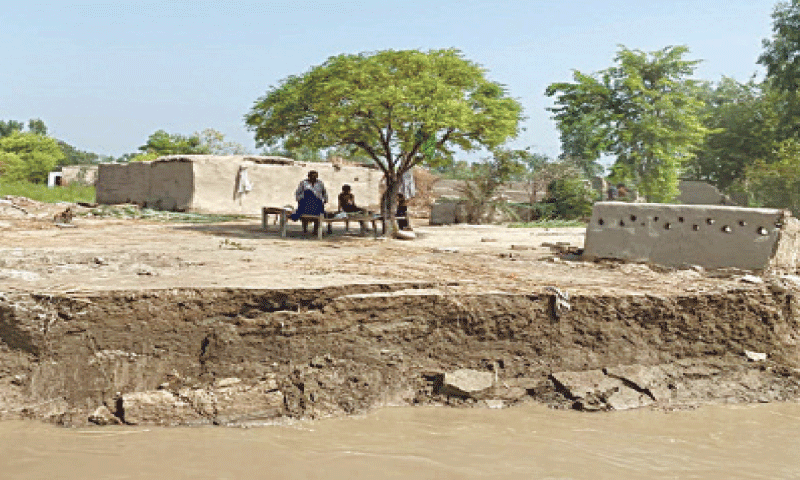 LOCALS sit among the ruins of their homes in Bulu Nashaib, after the river washed away the riverbank.&mdash;Photo by the writer