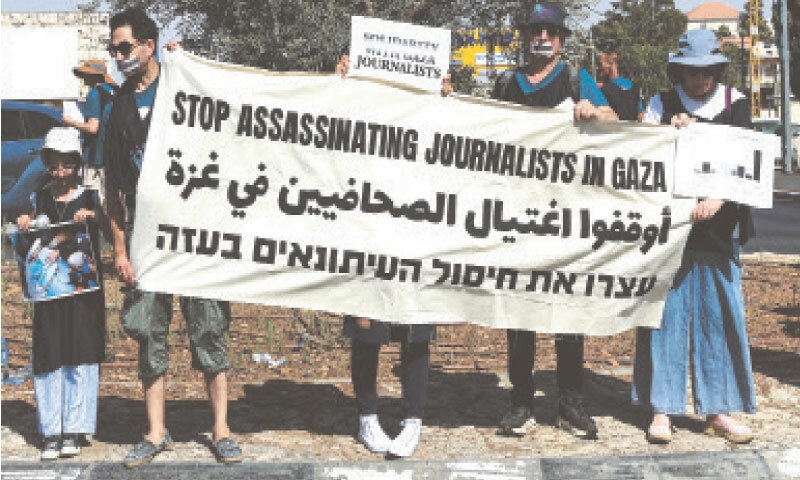 OCCUPIED WEST BANK: Palestinian and Israeli activists take part in a protest against starvation in Gaza and in solidarity with journalists.—Reuters OCCUPIED WEST BANK: Palestinian and Israeli activists take part in a protest against starvation in Gaza and in solidarity with journalists.—Reuters