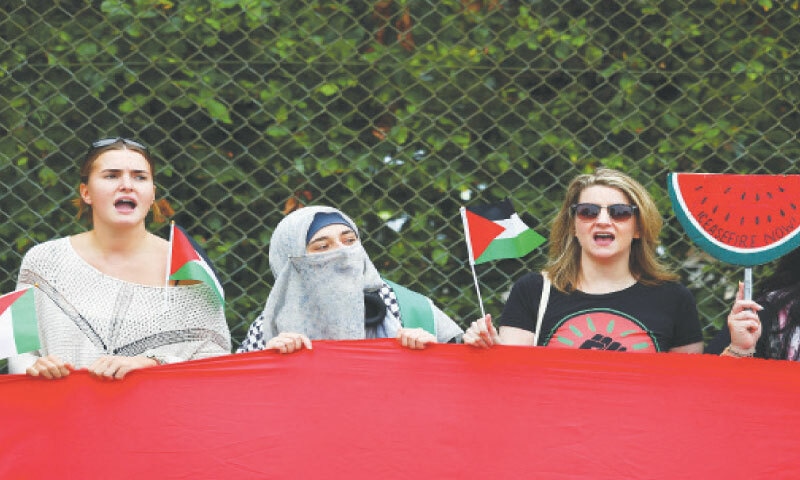 People shout slogans as demonstrators from the Palestine Solidarity Campaign call for an arms embargo on Britain’s weapons exports to Israel at Royal Air Force base in Buckinghamshire.—Reuters People shout slogans as demonstrators from the Palestine Solidarity Campaign call for an arms embargo on Britain’s weapons exports to Israel at Royal Air Force base in Buckinghamshire.—Reuters