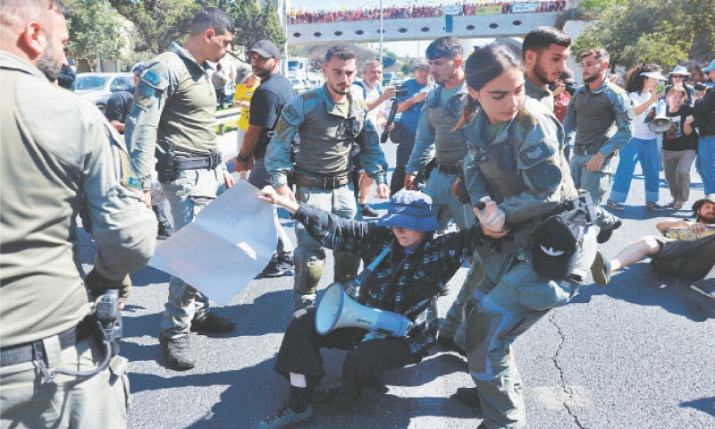 Security forces remove a protester from a street during a demonstration, calling for government action to secure prisoners&rsquo; release and an end to war.&mdash;AFP
