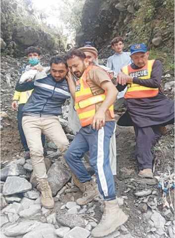 A patient from flood-affected Daen village is shifted to the Chatokhan area in Ghizer by a rescue team, as road access of the village remains cut off. —Photo by the writer