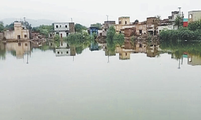 A part of Kundwal village near Lillah inundated by floodwaters  on Monday. &mdash; Dawn