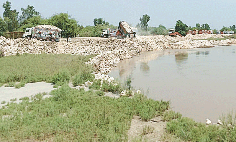 EMERGENCY stone-pitching work under way at the dyke on Monday.&mdash;Dawn