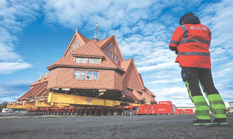 KIRUNA (Sweden): An employee of Swedish mining company LKAB monitors the wooden church, which is being moved five kilometers.&mdash;AFP