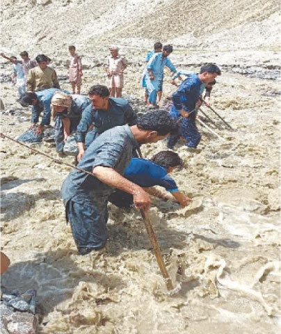 LOCALS work to restore a water channel in the Huracho area of Shigar.—Dawn