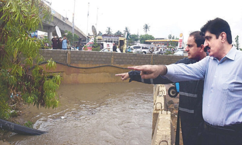 Chief Minister Murad Ali Shah and Mayor Murtaza Wahab inspect the flow of a storm water drain in the Nursery area.&mdash;Dawn