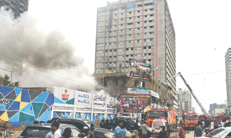 RESCUE teams work as smoke billows from a building on M.A. Jinnah Road, which houses a fireworks shop in the basement, following an explosion. &mdash;AFP