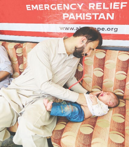 A doctor examines a child at a medical camp in Swat. — Dawn