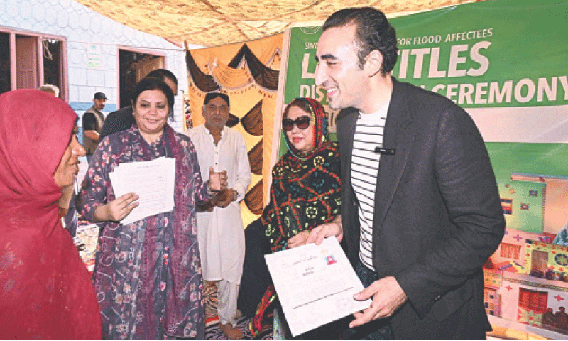 A WOMAN receives ownership documents of her home from PPP Chairman Bilwal Bhutto-Zardari in Ratodero on Saturday.&mdash;Dawn