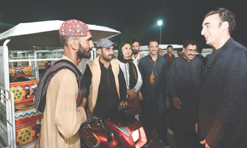 LARKANA: PPP Chairman Bilawal Bhutto-Zardari on Monday evening interacts with a man after he received a loader rickshaw under the Apna Rozgar Scheme.&mdash;Dawn
