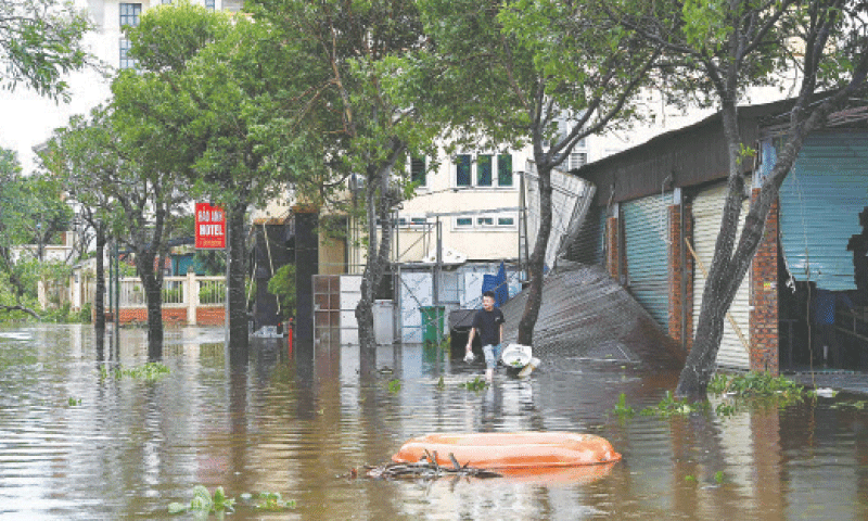 A MAN wades through a flooded street near a beach after Typhoon Kajiki passed through Vietnam&rsquo;s Nghe An province.&mdash;AFP