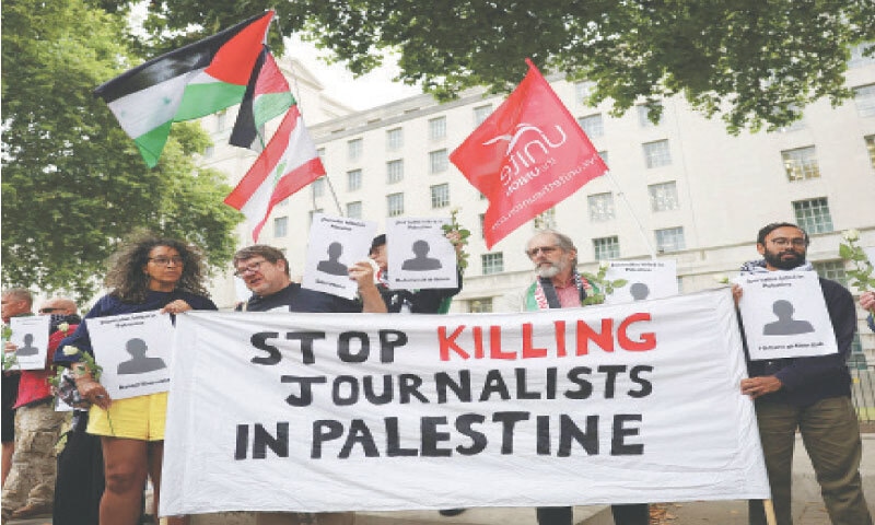 LONDON: Protesters hold Palestinian flags and banners outside 10 Downing Street on Wednesday during a vigil for journalists killed in the recent Israeli strike in Gaza.&mdash;AFP