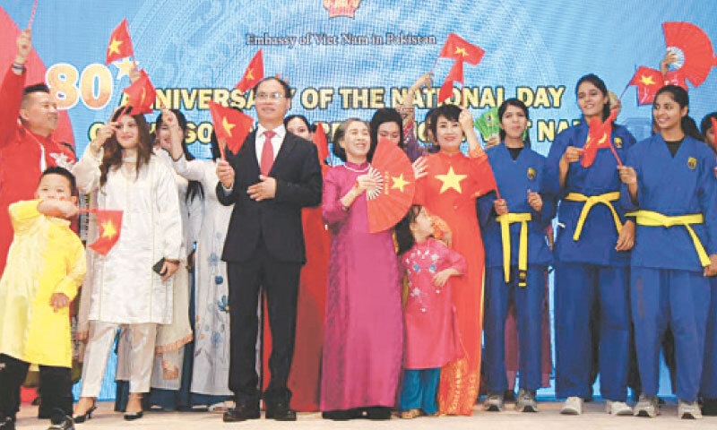 Ambassador of Vietnam Pham Anh Tuan, his spouse and other guests wave their national flags during a reception to mark the 80th National Day of the country in Islamabad on Thursday night. &mdash; White Star