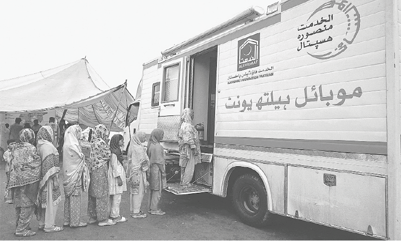 WOMEN displaced by the floods queue to receive medical assistance outside a mobile health unit at a makeshift camp in Chung.&mdash;AFP