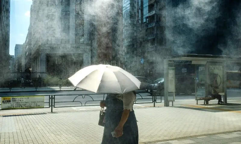 A woman with an umbrella walks in the scorching sun in Tokyo on September 1. — AFP A woman with an umbrella walks in the scorching sun in Tokyo on September 1. — AFP