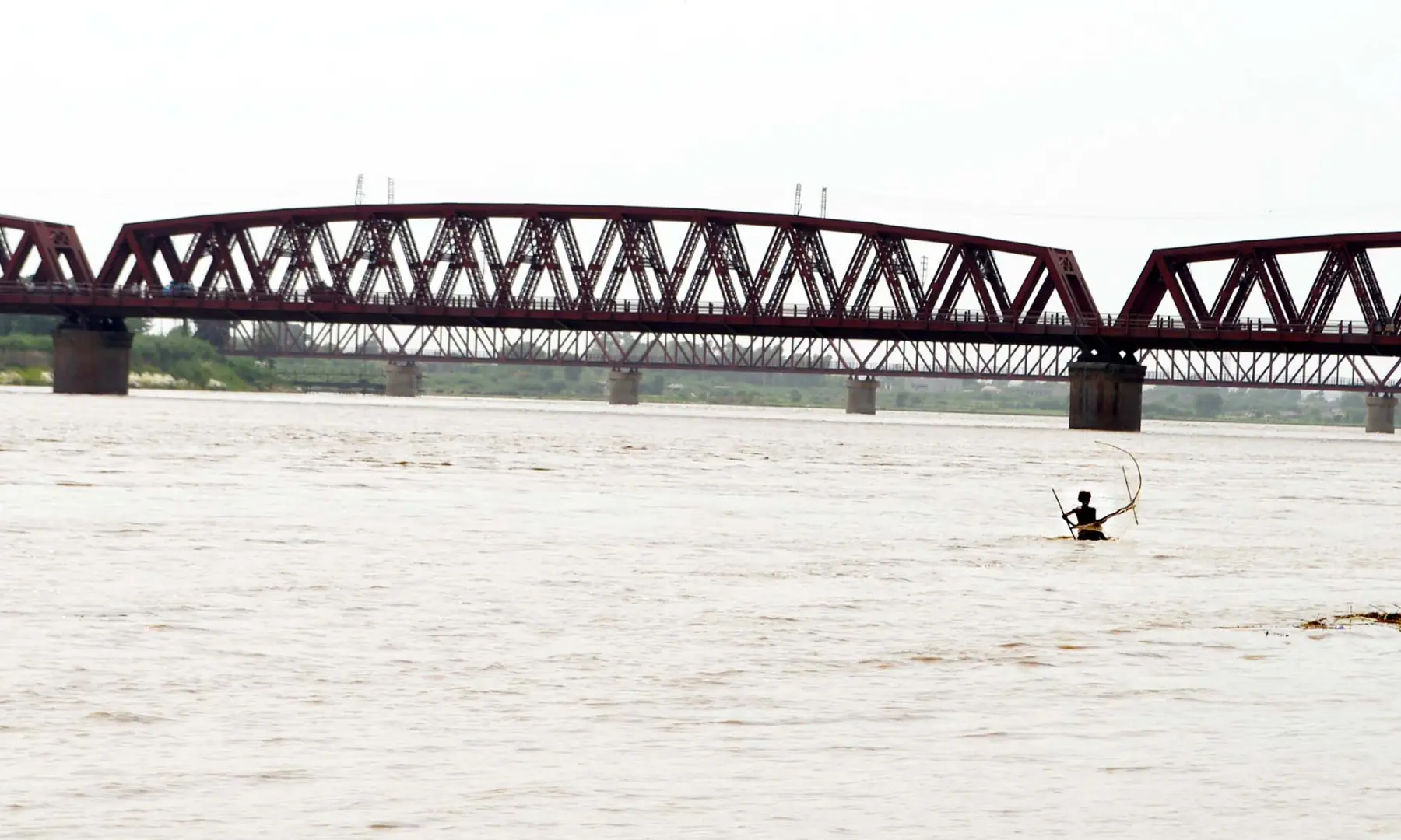 Fisherman Subhan Ali trying his luck to catch palla near Kotri-Hyderabad railway bridge in Indus river in Hussainabad with his small net.