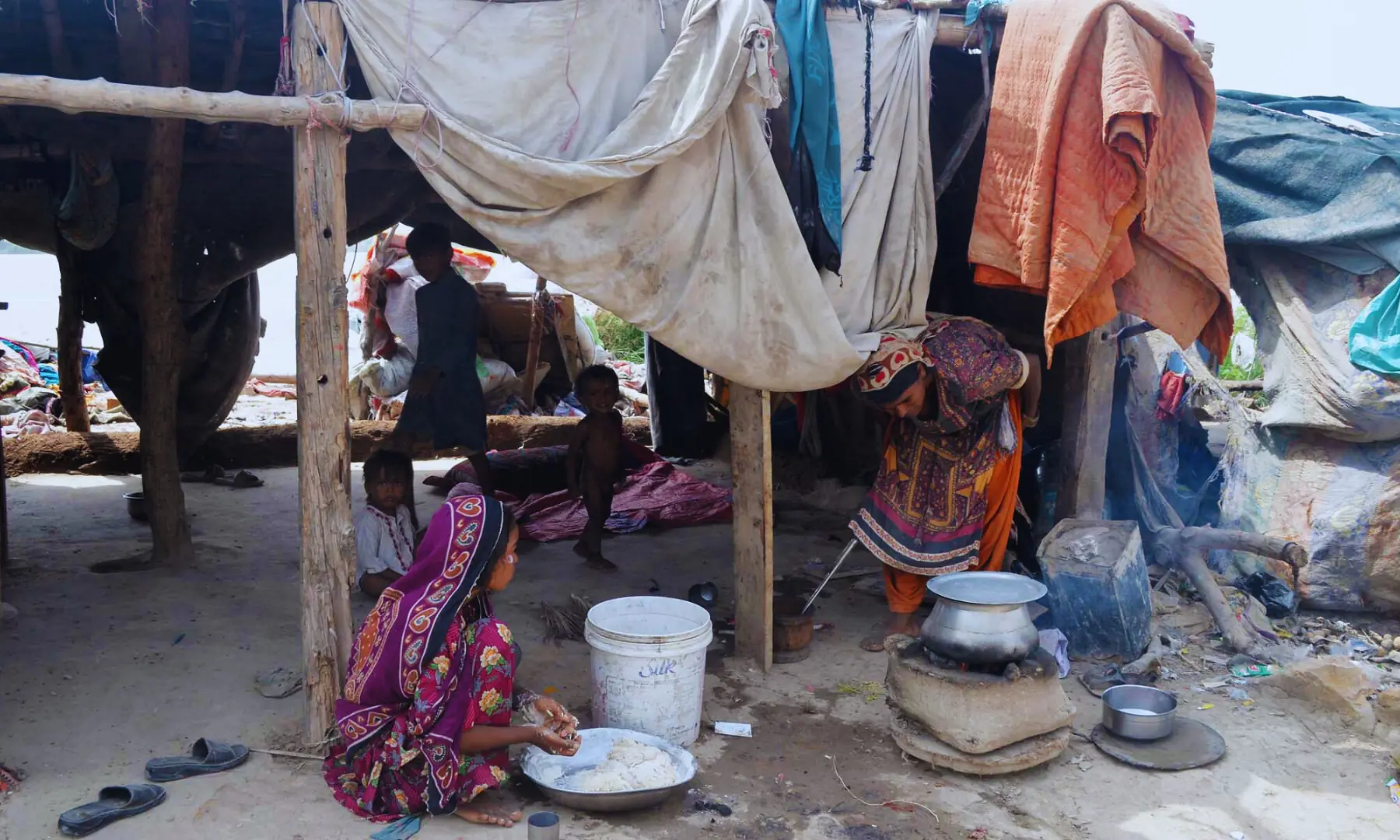 A woman of the nomad family kneading wheat flour.