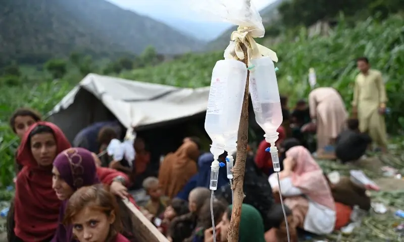 Afghan injured women and girls look on as they receive treatment, with intravenous drips in the foreground at a field following earthquakes in the Mazar Dara village of Nurgal in Eastern Afghanistan, on September 1. — AFP