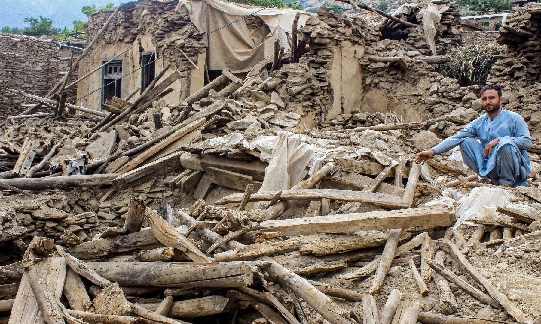 An Afghan man sits amid the remains of a damaged house, in the aftermath of an earthquake at the Dara-i-Nur district of Nangarhar province, Afghanistan on September 3. — AFP