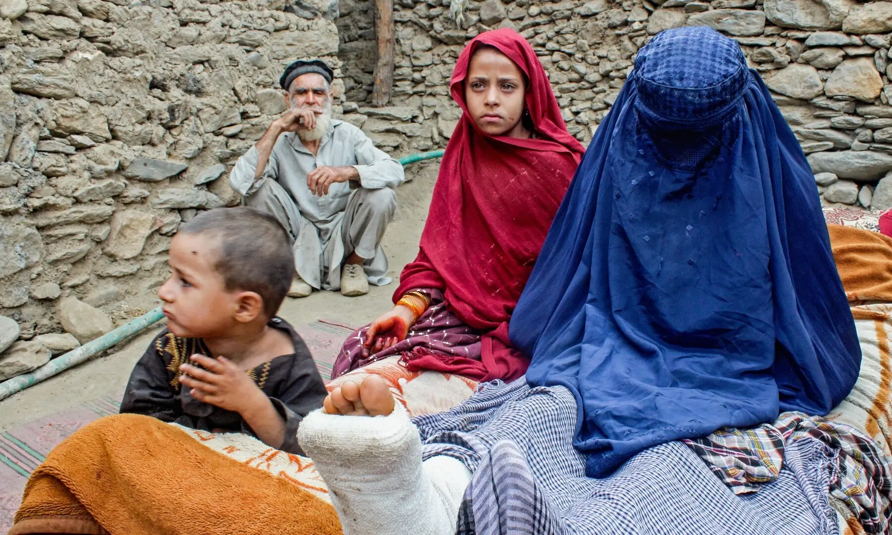 An Afghan woman with an injured leg sits beside children outside a house, in the aftermath of an earthquake at the Dara-i-Nur district of Nangarhar province, Afghanistan on September 3. — AFP