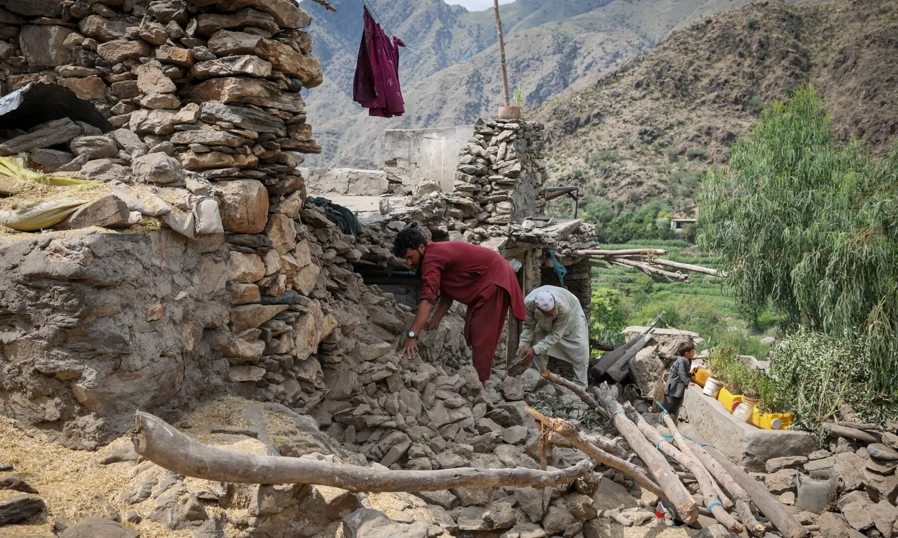 Afghan men look for their belongings amidst the rubble of a collapsed house after a deadly magnitude 6 earthquake that struck Afghanistan on Sunday in Nurgal district, Kunar province, Afghanistan on September 3. — Reuters