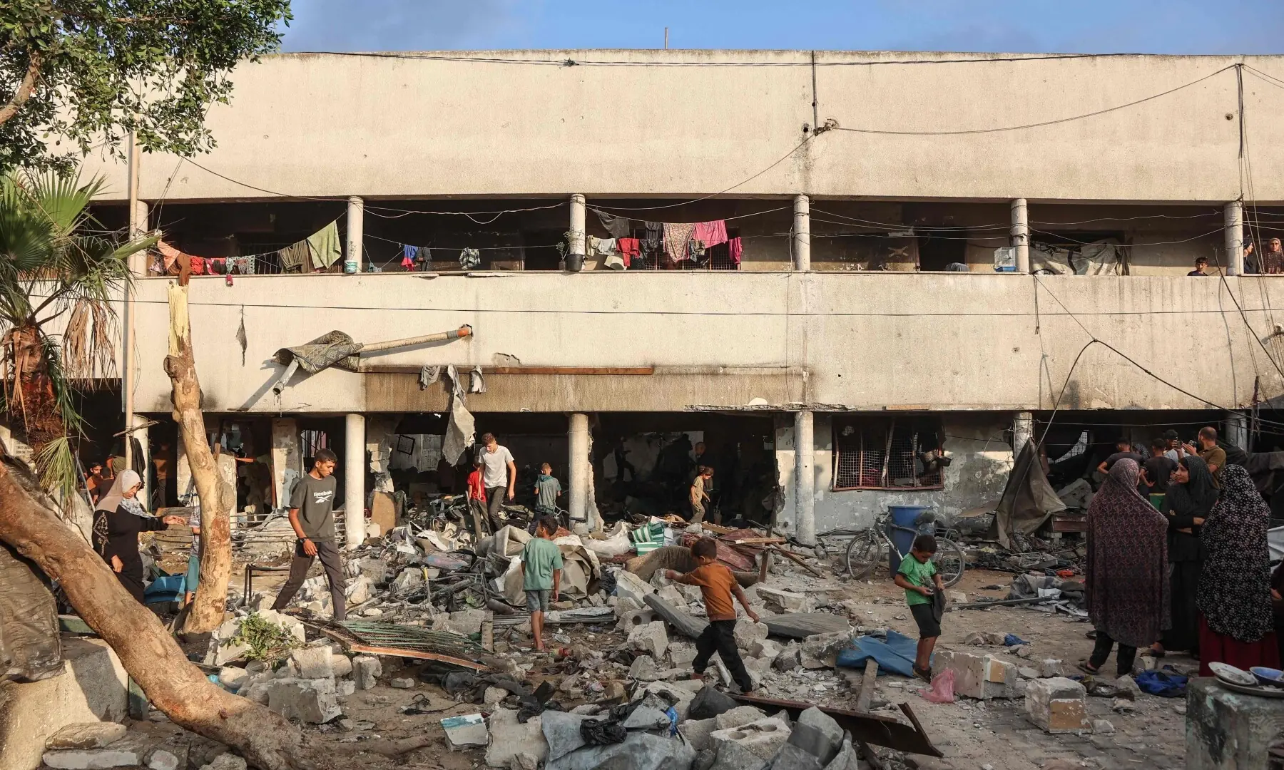 Displaced Palestinians salvage some of their belongings amid the rubble, in the yard of the al-Farabi school turned shelter, after it was hit by an Israeli strike, in Gaza City in the northern Gaza Strip on Sept 7, 2025. — AFP