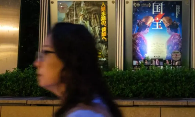  A woman walks past the poster of Japanese movie &ldquo;Kokuho&rdquo; (R) outside a cinema in Tokyo&rsquo;s Roppongi district on September 4, 2025. &mdash; AFP/Philip Fong 