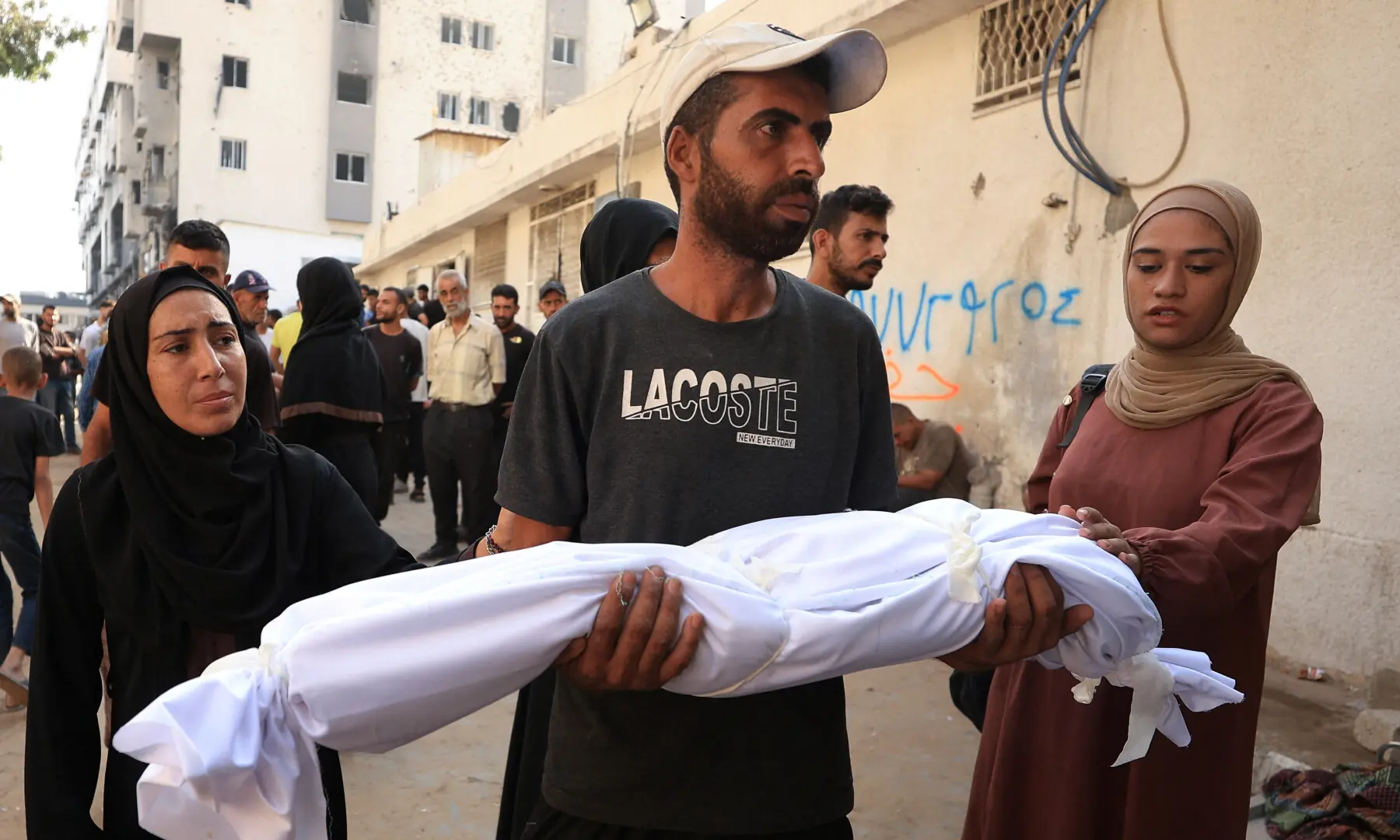 A man carries the shrouded body of a child during the funeral of Palestinians killed in overnight Israeli strikes, according to medics, at Al-Shifa Hospital in Gaza City on Sept 8, 2025. — Reuters/Dawoud Abu Alkas